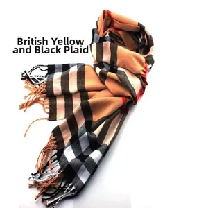 Detailed macro view of a classic yellow and black British plaid scarf with fringe detail