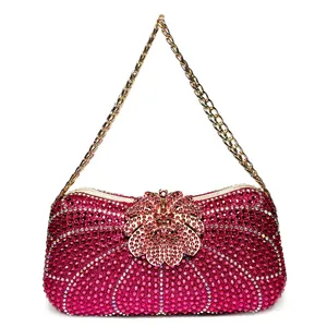 Detailed close-up view of a luxury fuchsia rhinestone evening clutch with gold flower clasp