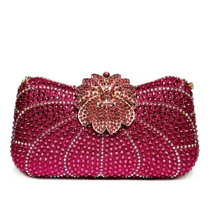 Close-up of luxury fuchsia rhinestone evening clutch with flower crystal clasp.