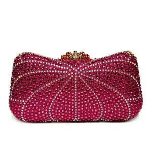 Close-up of a luxurious fuchsia rhinestone-encrusted evening clutch with gold clasp.