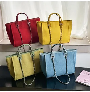 Detailed view of four colorful large-capacity canvas tote bags with chain handles.