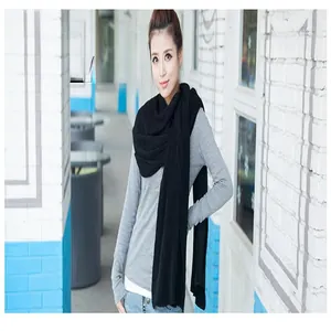 Woman wearing a large black winter knitted scarf in a casual outdoor setting