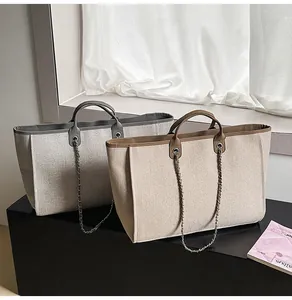 Close-up view of two stylish large capacity tote bags with elegant metal chain straps