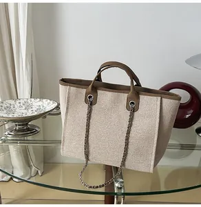 Detailed view of large capacity canvas tote bag with chain strap and brown trim