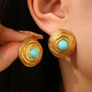 Close-up of vintage 18k gold plated spiral earrings with center turquoise stone