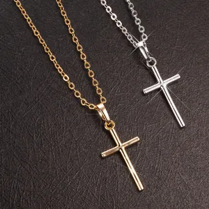 Detailed close-up of gold and silver cross pendants with polished metallic finish.