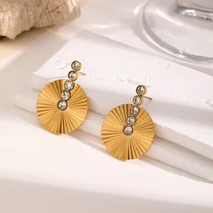 Detailed view of gold-plated stainless steel sunburst earrings with sparkling rhinestones.