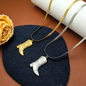 Detaillierte Nahaufnahme von Stiefelanhängern in Gold und Silber an Schlangenketten