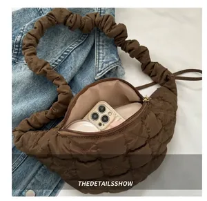 Detailed view of interior capacity for brown quilted hobo bag with accessories