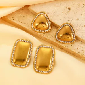 Close-up of elegant gold triangle and rectangle earrings with sparkling stones
