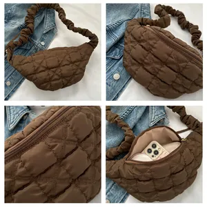 Detail view of brown quilted crescent bag with ruffled strap and interior space