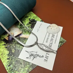 Detaillierte Nahaufnahme einer Fisch-Halskette aus Edelstahl mit eleganter Reliefgravur