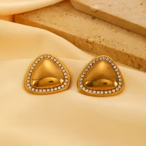 Detailed macro view of gold-plated triangular stud earrings with crystal border.