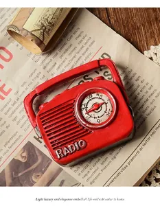 Vintage red resin radio ornament with detailed dial and antique paper background.