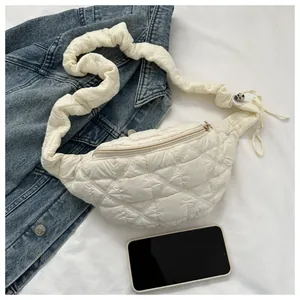 Detailed view of a white quilted fanny pack featuring a trendy scrunchie strap design.