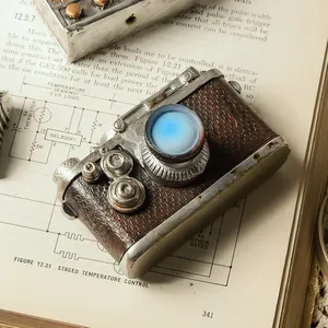 Vintage resin camera ornament for home decor on an open antique book backdrop