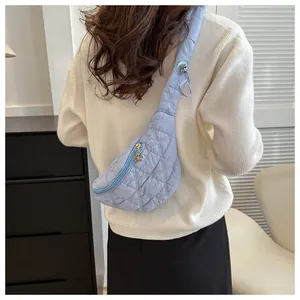 Detailed back view of a stylish light blue quilted fanny pack worn with a white sweater.