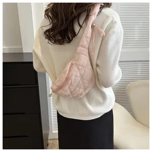 Stylish pink quilted crossbody chest bag shown on model's back in a minimalist setting