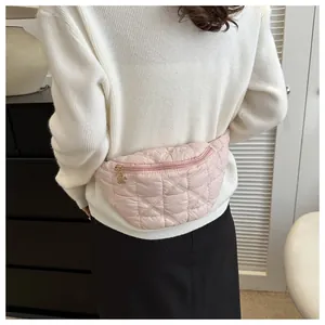Close-up of stylish pink quilted chest bag worn by model in casual indoor setting