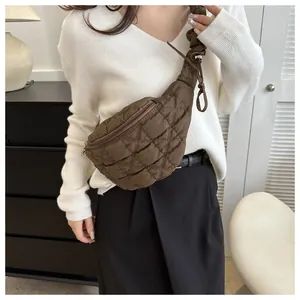 Brown quilted crossbody chest bag shown as worn by a model in a lifestyle setting.