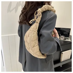 Fashionable beige quilted crescent chest bag featuring a trendy ruched shoulder strap