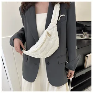 White quilted chest bag worn over a grey blazer for a stylish fashion look