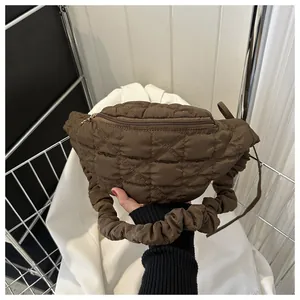 Detailed view of fashionable brown quilted chest bag with stylish scrunchie strap
