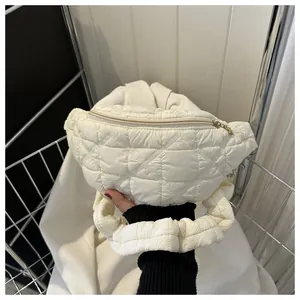 Close-up view of a stylish white quilted fanny pack featuring a soft padded handle and zipper