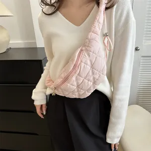 Stylish pink quilted crossbody chest bag for women worn over a white sweater
