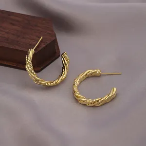 Elegante goldene Mobius Twist Creolen mit hohlem, verschlungenem minimalistischem Design.