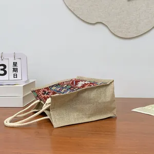 Detailed side view of an ethnic style jute tote bag with tribal patterns and rope handles.