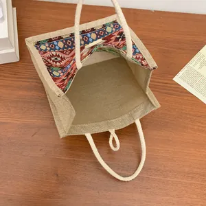 Detail of ethnic style linen tote bag showing intricate embroidered pattern and interior
