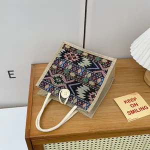 Detailed view of ethnic tribal pattern woven tote bag with rope handle on wood surface