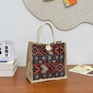 Ethnic pattern woven jute tote bag with white rope handles and decorative button closure