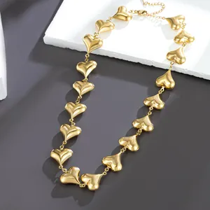 Detailed view of a golden stainless steel necklace featuring hollow puffy heart shaped links