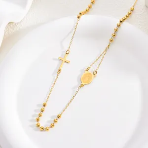 Detailed close-up of a 3mm gold rosary necklace featuring a cross and Mary medal.