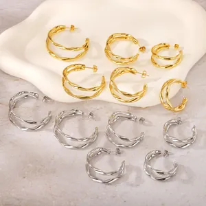 Vue détaillée des boucles d'oreilles créoles torsadées en acier titane doré et argenté