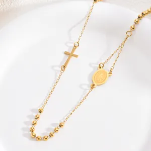 Detail of gold stainless steel 3mm rosary necklace with cross and religious medal.