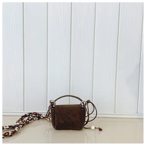 Vintage brown suede mini crossbody bag with a slim cord strap and top handle detail