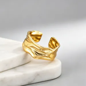 Dettaglio macro della trama a onde dorate su anello regolabile in acciaio titanio