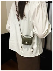 Back view of a model wearing a vintage green suede mini crossbody coin purse with beads