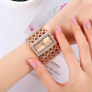 Close-up of elegant rose gold square watch with rhinestone encrusted bracelet strap