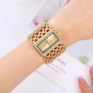 Detailed close-up of a luxury women's gold-tone quartz watch with wide crystal bracelet
