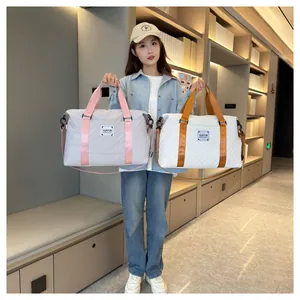 Mannequin tenant des sacs de voyage matelassés gris et blancs dans un décor moderne