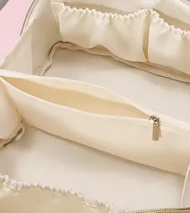 Innenansicht der Fächer und Reißverschlusstasche einer cremefarbenen Kosmetiktasche