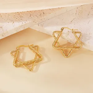 Détail de boucles d'oreilles créoles en forme d'étoile avec texture de corde torsadée