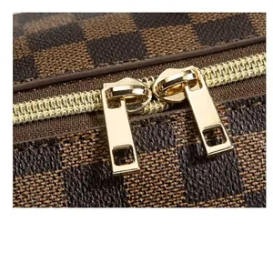 Detailansicht einer braun karierten Kosmetiktasche mit goldfarbenem Reißverschluss.