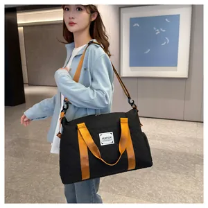 Détail du grand sac de fitness noir matelassé avec sangles orange sur mannequin