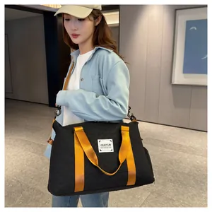 Vue latérale d'un grand sac de voyage noir avec des sangles orange sur un mannequin