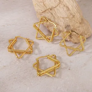 Vue détaillée de boucles d'oreilles étoiles dorées avec finitions lisses et texturées.
